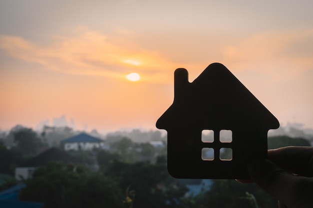 Model van het huis in de hand van een verzekeringsagent of een verkoper.