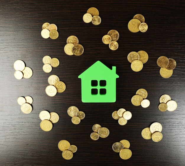 Model van huis met munten op houten tafel closeup