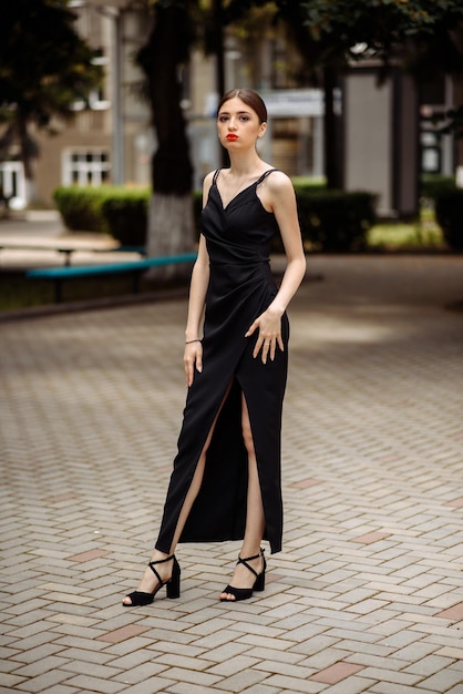 Photo model wearing a black dress with a long thin belt