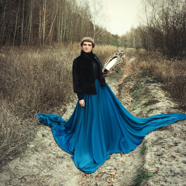 Model wearing blue skirt posing as a queen