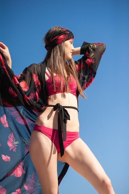 A model wears a black kimono with red flowers on it.