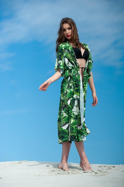 A model wears a green kimono and a black top with a palm leaf print