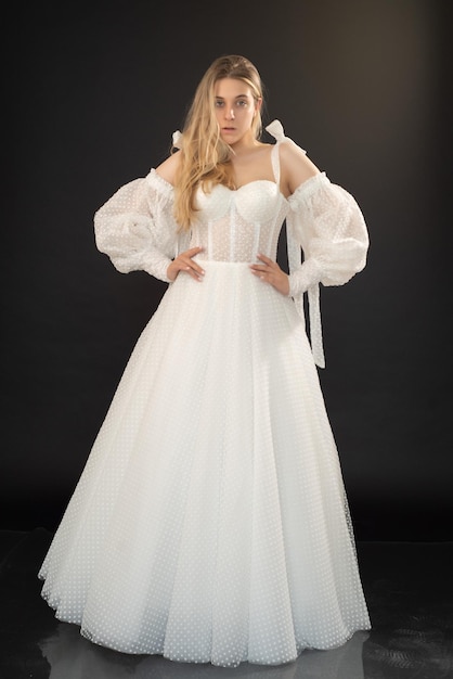 A model wears a white wedding dress with a long sleeved top and a long sleeved top.