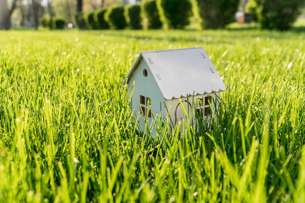 緑の芝生の上の白い木造住宅のモデル