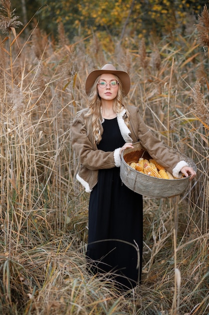 Model with corn in dry grass in autumn