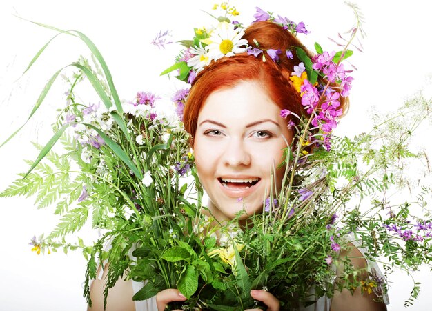 Model with large hairstyle and flowers in her hair and with bouquet flowers