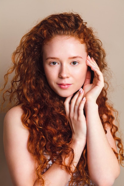 Model with long natural red curly hair and perfect skin with little freckles without cosmetics