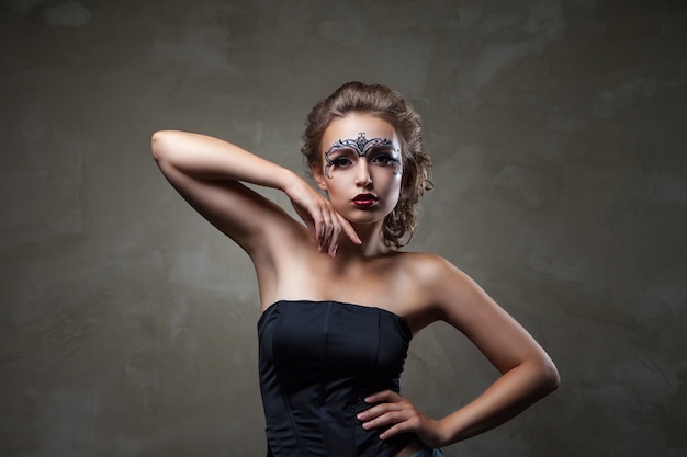 Model with ornamental face art and bare shoulders.Studio shot