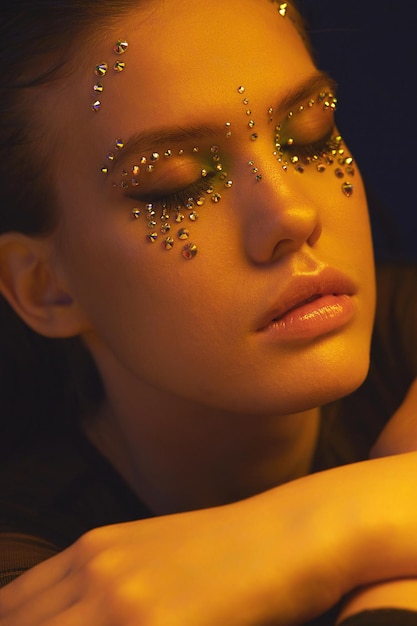 Photo a model with rhinestone makeup closed her eyes