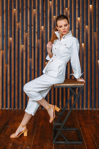 A model woman in a light white summer suit. Demonstration of clothing for the showroom