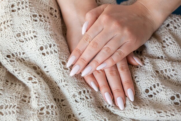 Photo model woman showing light pale pink nude shellac manicure o