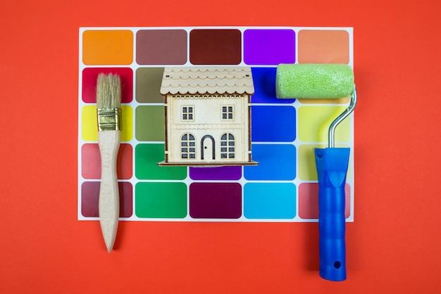색상 팔레트와 페인트 브러시가 있는 목조 주택 모델
