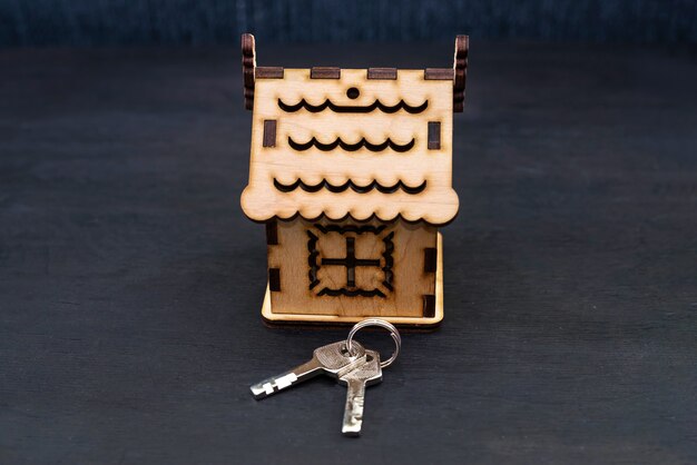 Model of a wooden house with keys. Building, borrowing, real estate or buying a new home.