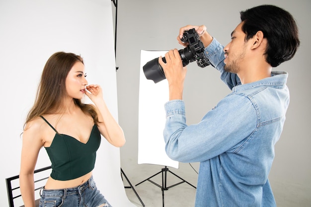 Photo model young woman posing for photo taken with professional photographer in studio