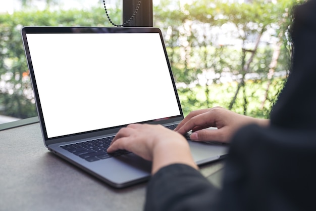 Modelbeeld van een vrouw die en op laptop met het lege witte Desktopscherm gebruiken typt