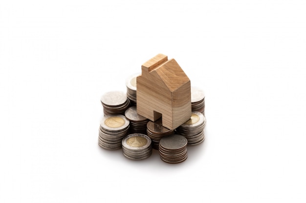 Modeled wooden house placed on a stack of coins