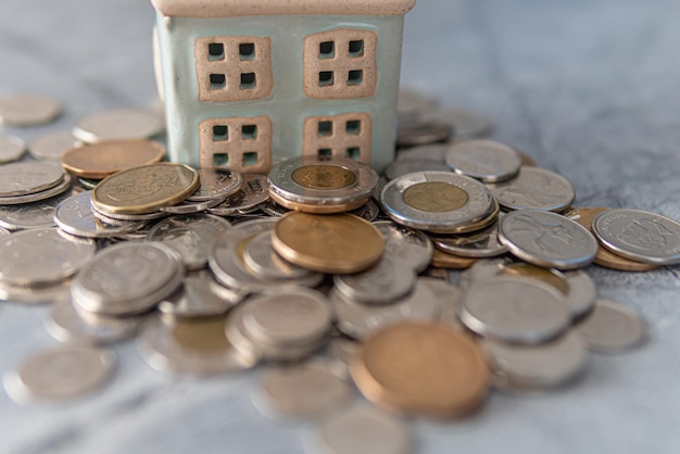 Foto modelhuis met stapel munten huisfinanciering hypotheekconcept