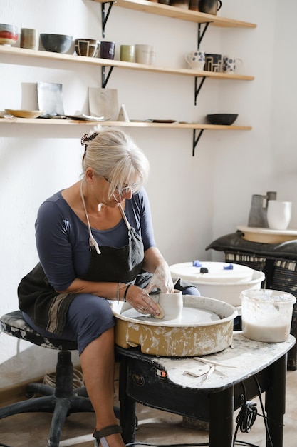 Modeling from clay on a potters wheel in the pottery workshop