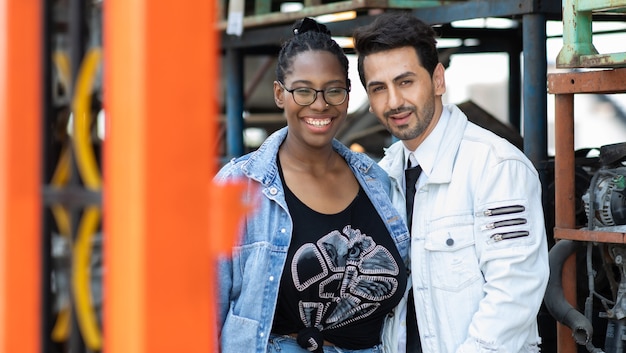 Modeling portrait photo. African American female employee worker and hispanic man manager working together at old auto and car parts warehouse store.