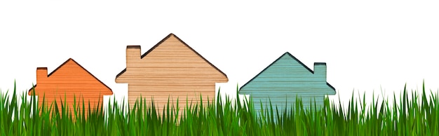 Modellen van huizen van verschillende kleuren op een achtergrond van groen gras. Geïsoleerde achtergrond. Concept voor onroerend goed reclame. Kopen, verkopen een huis huren. Hypotheek. Ruimte kopiëren. Bannerformaat.