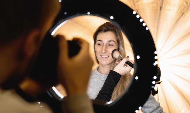 modellen worden geconfronteerd met poseren voor de camera door een ringlichtlamp bij het fotograferen en make-upartiest