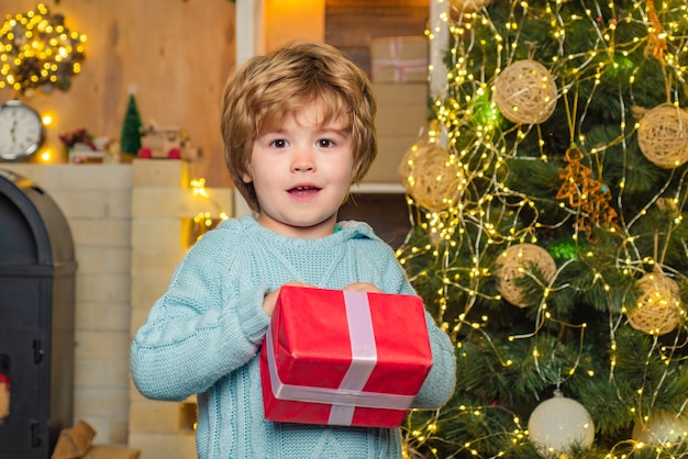 Models child having fun with gift. Gift emotions. Happy kid having fun with gift. Winter kid. Winter