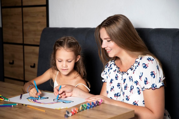 Models family mom and daughter draw together common activity Place for text