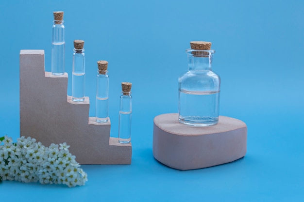Models of samples of perfumery, aromatic oils on podiums on a colored background. Mock up with copy space. Bottles for branding and labels, front view.