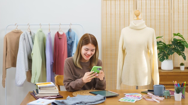 Modeontwerpconcept Modeontwerper chatten met klant op smartphone over detail van kleding