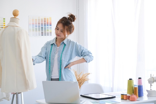 Modeontwerper aan het werk in studio, tekening knippen, jurk naaien