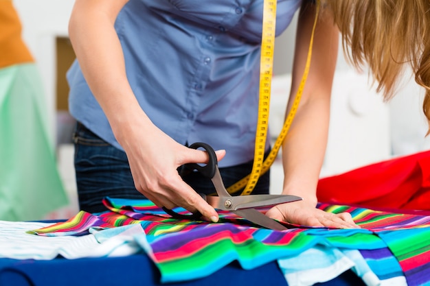 Modeontwerper of kleermaker in de studio werken