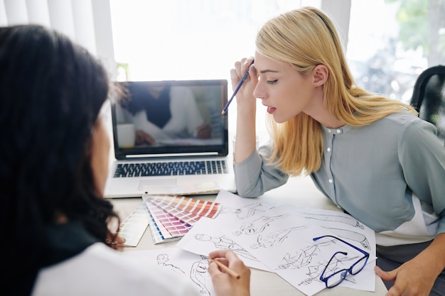 Foto modeontwerpers werken aan collectie