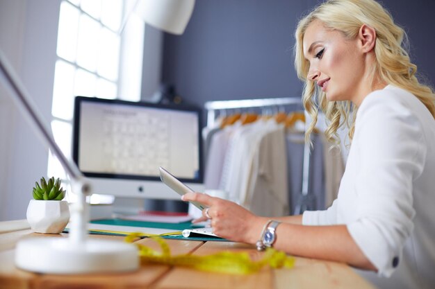 Foto modeontwerpster die in de studio aan haar ontwerpen werkt