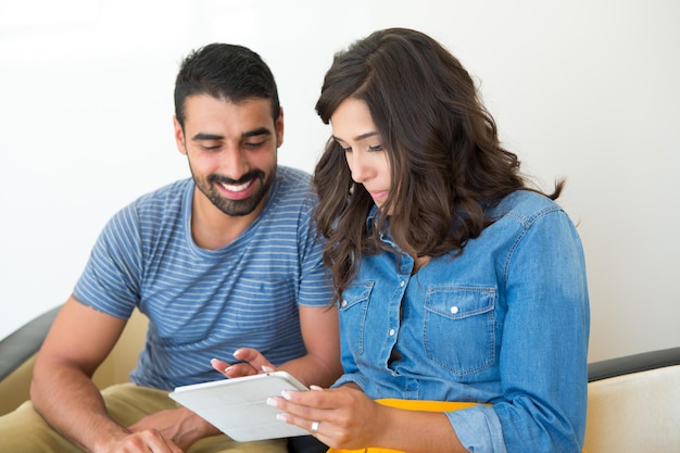 Modepaar dat samen zit en een tablet gebruikt