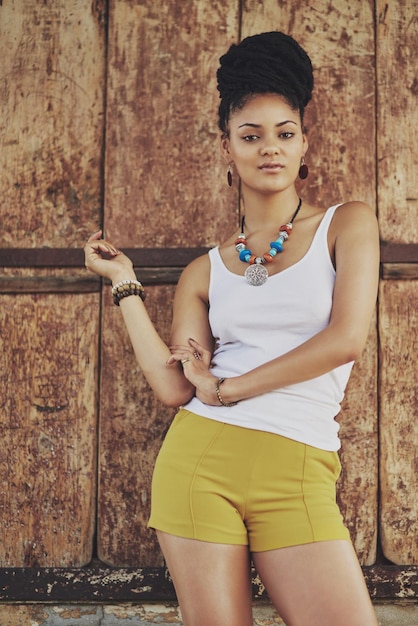 Foto modeportret en trendy vrouw met stijl in de stad om te reizen tegen een houten achtergrond zwarte vrouw stijlvol en zelfverzekerd met een spaanse vrouw die poseert met een eigentijdse edgy stijl