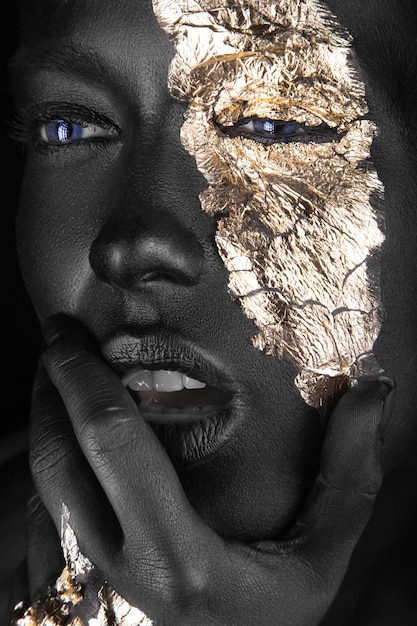 Modeportret van een donkerhuidig meisje met gouden make-up Beauty face