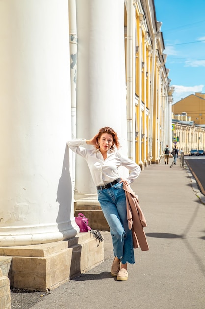 Modeportret van een jonge, stijlvolle vrouw die door de straat loopt Zonnige zomerdag in de stad