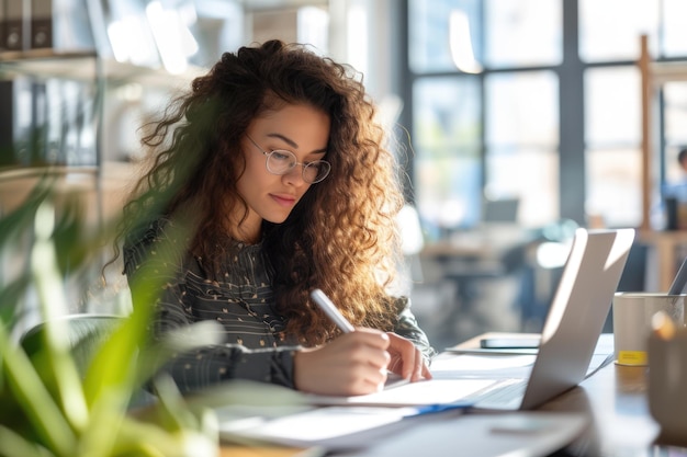 Moderate Depth of Field Young engaged American woman in an open office setting writing things down