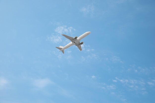 Modern airplane flying in blue sky low angle view