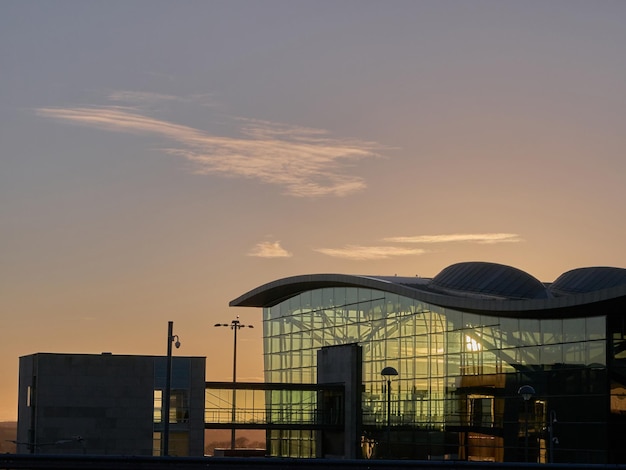 アイルランドのコークにある近代的な空港の建物と日没の背景