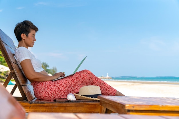 アジアの女性ビジネスマン夏の晴れた日に熱帯のビーチでインターネットを搭載したノートパソコンを使って働く女性フリーランサーアウトドアライフスタイル仕事旅行夏のビーチホリデー休暇を楽しむ - ライブドアニュース
