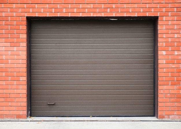 Modern automatic lifting gates on the brick wall of garage