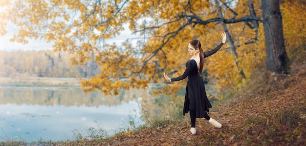 Modern ballet dancer in the autumn park by the lake Freedom harmony and unity with nature