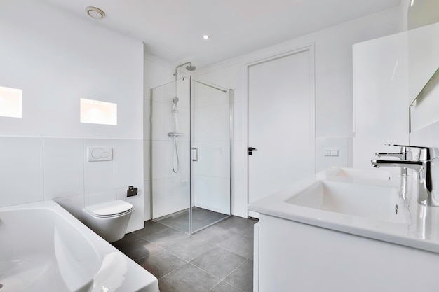 Современный дизайн ванной комнаты с черным кафельным полом и белыми стенами и окном