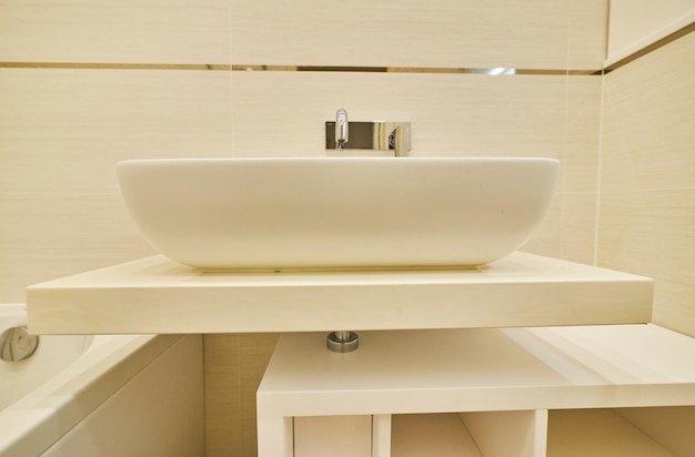 Современный умывальник для ванной комнаты с хромированным смесителем и серой плиткой