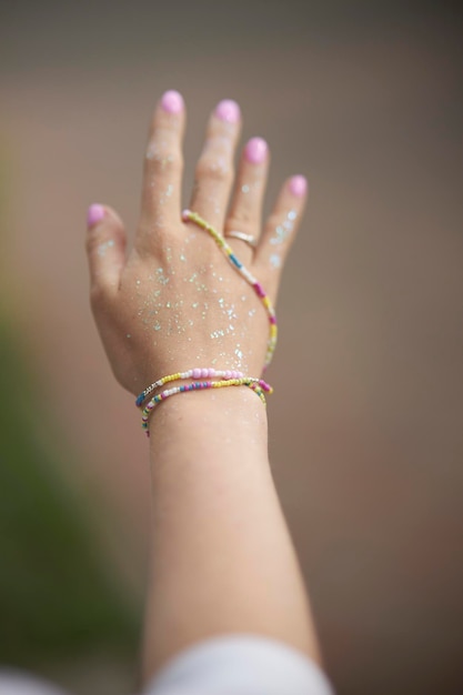 Modern beaded jewelry on the girl\'s hand. rings and bracelets\
on the girl\'s hand. multi-colored