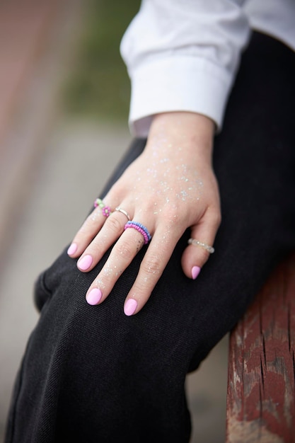 Modern beaded jewelry on the girl\'s hand. rings and bracelets\
on the girl\'s hand. multi-colored