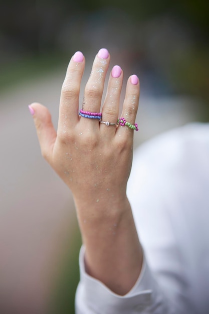 Modern beaded jewelry on the girl's hand. Rings and bracelets on the girl's hand. multi-colored