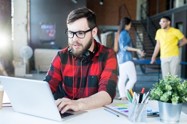 Modern Bearded Man Using Laptop in Coworking Space