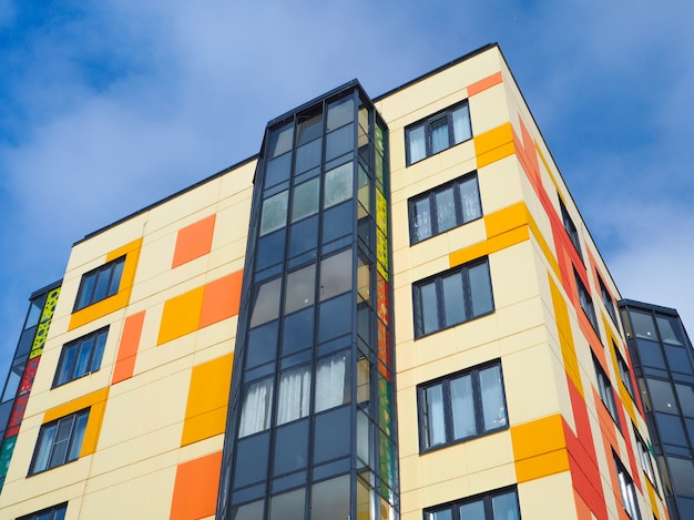 Modern beautiful new buildings. Colored wall on the background of blue sky.